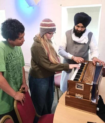 Young people trying out the harmonium, an instrument used in Sikh music