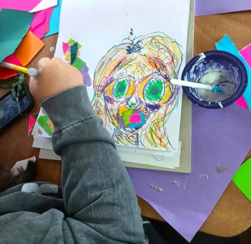 Mixed media drawing of a woman's face, semi abstract with coloured paper collage and scribble effect colourful pen