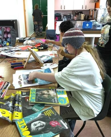 girls painting and creating collages with magazines on the table close to them