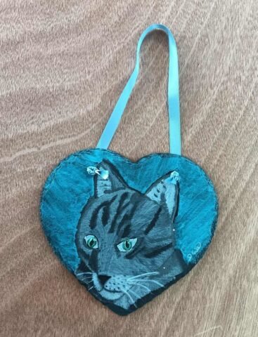 painting on a slate heart of a cat in blue tones