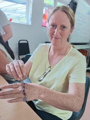 Woman holding up a keyring that she has just made